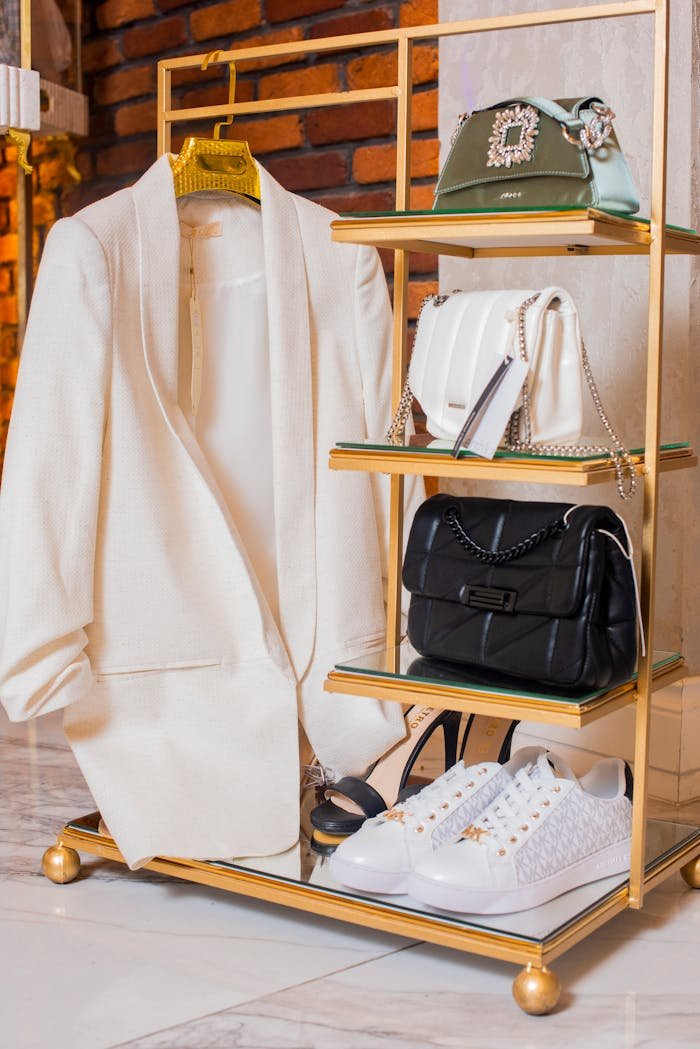 Stylish ensemble showcasing a white jacket, high heels, and luxury handbags.